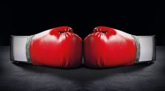 Zwei rote Boxhandschuhe auf schwarzem Hintergrund.