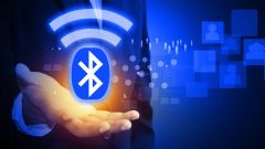 Eine Hand hält ein abstraktes, digitales Bluetooth-Symbol.